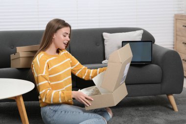 Duygusal kadın paketleri evde boşaltıyor. Çevrimiçi mağaza