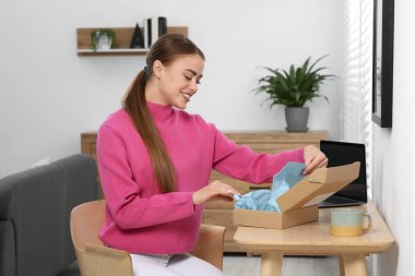 Evde paketleri açan mutlu kadın. Çevrimiçi mağaza