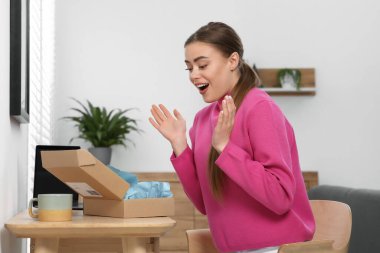 Duygusal kadın paketleri evde boşaltıyor. Çevrimiçi mağaza