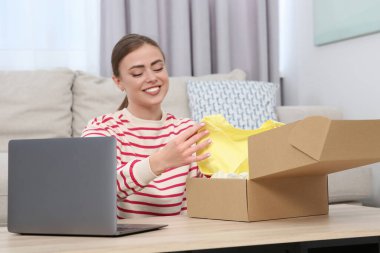 Evde paketleri açan mutlu kadın. Çevrimiçi mağaza
