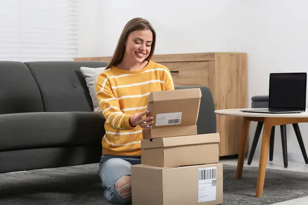 Happy woman with stack of parcels at home. Online store