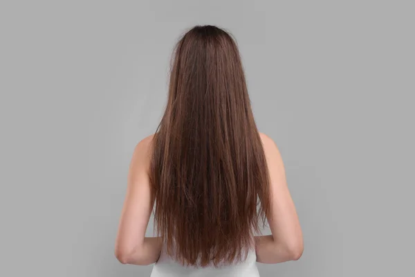 Žena Poškozenými Vlasy Světle Šedém Pozadí Pohled Zezadu — Stock fotografie