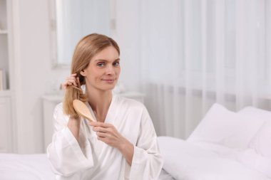 Odada saçını tarayan güzel bir kadın.