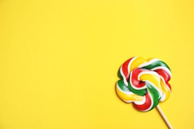 Sarı arka planda parlak lolipopla kalın. Metin için boşluk