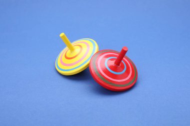 Mavi arka planda iki parlak dönen kapak. Oyuncak girdabı