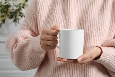 Beyaz bardağı elinde tutan kadın, yakın plan. Tasarım için model