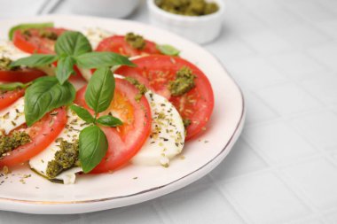 Beyaz fayanslı masada pesto soslu lezzetli Caprese salatası, yakın plan. Metin için boşluk