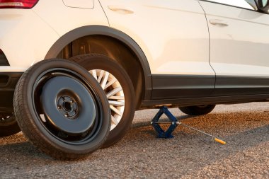 Araba yol kenarında makas kriko ve yedek tekerlekle kaldırıldı.