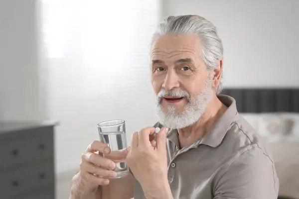 Starszy Mężczyzna Szklanką Wody Bierze Pigułki Domu — Zdjęcie stockowe