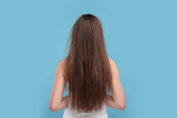Жінка Пошкодженим Брудним Волоссям Світло Блакитному Тлі Вид Ззаду — стокове фото