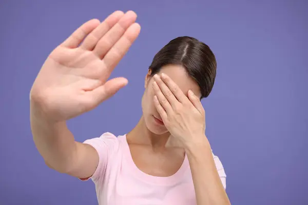 Peinliche Frau Verdeckt Gesicht Mit Hand Auf Violettem Hintergrund — Stockfoto