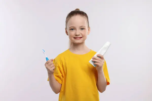 Menina Feliz Segurando Escova Dentes Tubo Pasta Dentes Fundo Branco — Fotografia de Stock