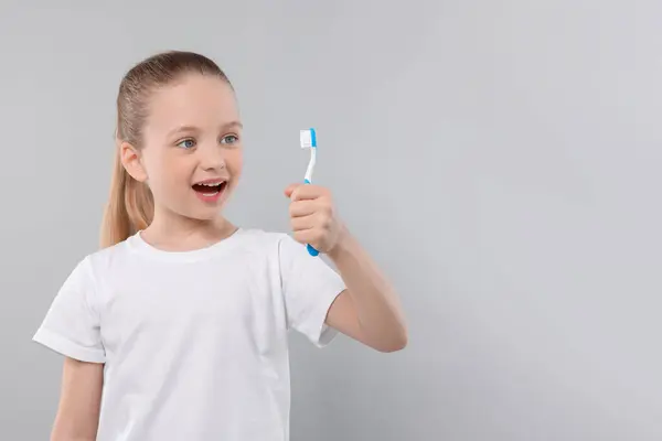 Menina Feliz Segurando Escova Dentes Fundo Cinza Claro Espaço Para — Fotografia de Stock
