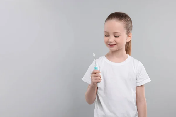 Щаслива Дівчина Тримає Електричну Зубну Щітку Світло Сірому Тлі Простір — стокове фото