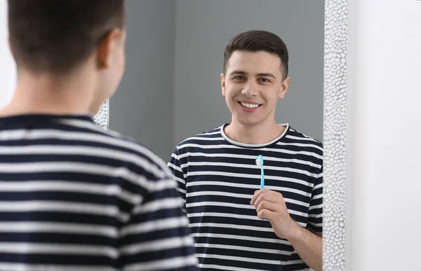 バスルームの鏡の近くに歯ブラシが付いている幸せな男 — ストック写真