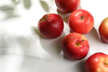 Beyaz mermer masaya su damlatan taze kırmızı elmalar. Metin için boşluk