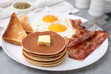 Gri masada omlet ve pastırmayla servis edilen leziz krepler, yakın plan.