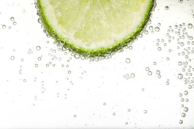 Soda ile sulu limon dilimi beyaz arka planda, yakın plan. Metin için boşluk