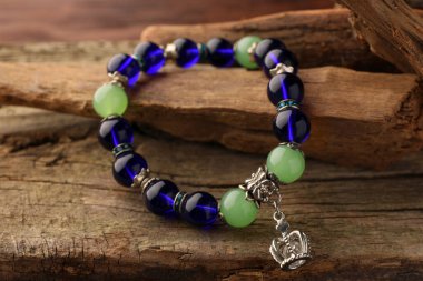 Ahşap masa üzerinde değerli taşlar olan güzel bir bilezik sunumu, yakın plan.