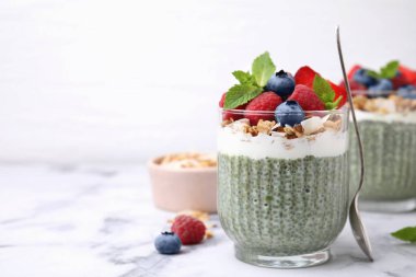 Lezzetli kiraz pudingi, yulaf ezmesi ve beyaz mermer masada böğürtlen, yakın plan. Mesaj için yer var. Sağlıklı kahvaltı.