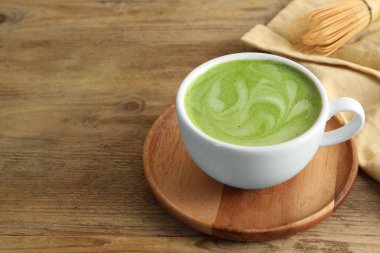 Ahşap masada bir fincan aromatik kibrit latte. Metin için boşluk