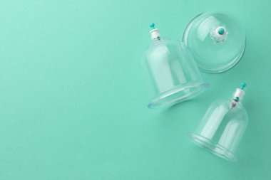 Turkuaz arka planda plastik bardaklar, metin için yeri olan düz yataklar. Fincan terapisi.