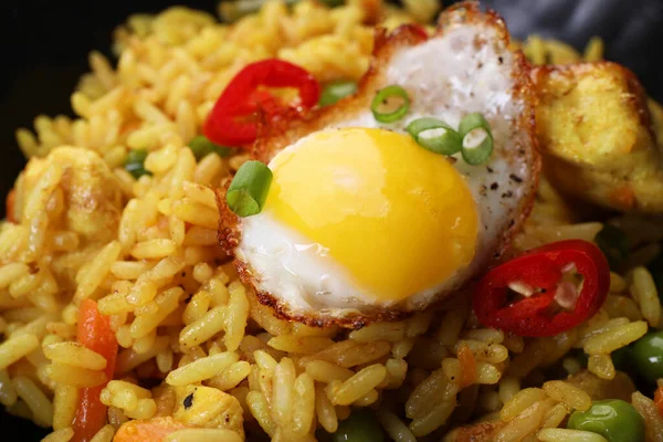 Tasty rice with meat, egg and vegetables in bowl, closeup