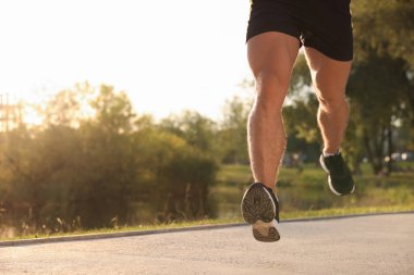 Güneşli bir günde parkta göletin yanında koşan bir adam, yakın plan. Metin için boşluk