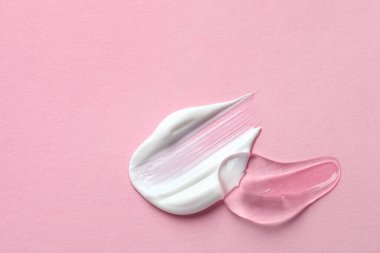 Pembe arka planda şeffaf jel ve beyaz krem örnekleri. Metin için boşluk
