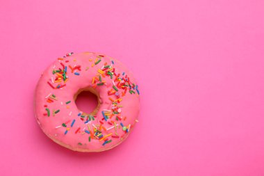 Tatlı jöleli donut pembe arka plan üzerine serpiştirilmiş, üst manzara ve metin için alan. Lezzetli şekerlemeler.
