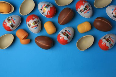 Sveti Vlas, Bulgaristan - 29 Haziran 2023: Açık mavi zemin üzerinde Kinder Sürpriz Yumurtalar ve plastik kapsüller, düz zemin. Metin için boşluk