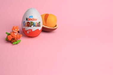 Sveti Vlas, Bulgaristan - 3 Temmuz 2023: Kinder Sürpriz Yumurtaları, açık plastik kapsül ve pembe arka planda oyuncak, metin için alan