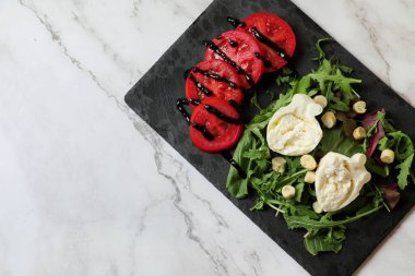 Lezzetli burrata peyniri, domates ve roka beyaz mermer masa, üst manzara. Metin için boşluk