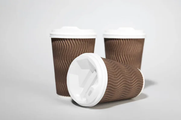 薄い灰色の背景に白いふたが付いている紙コップ コーヒー — ストック写真