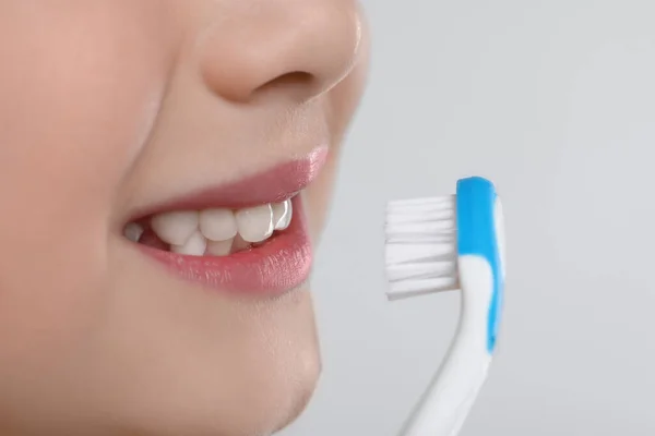 Κορίτσι Βουρτσίζει Δόντια Της Οδοντόβουρτσα Ανοιχτό Γκρι Φόντο Κοντινό Πλάνο — Φωτογραφία Αρχείου
