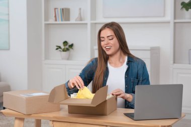 Duygusal kadın paketleri evde boşaltıyor. Çevrimiçi mağaza