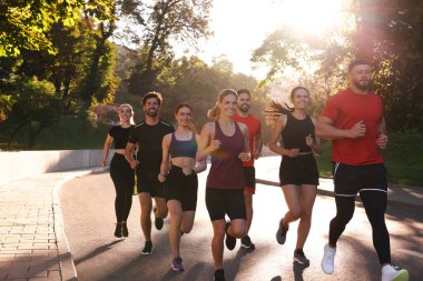 Güneşli bir günde dışarıda koşan bir grup insan.