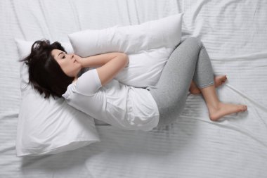 Yatakta uykusuzluk çeken genç bir kadın.