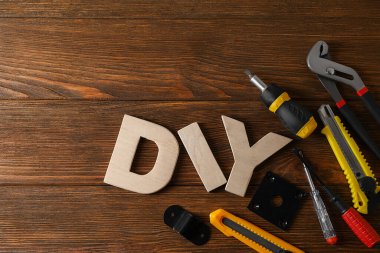 Harflerden yapılmış kısaltma DIY ve ahşap masa üzerinde farklı aletler, düz yatıyordu. Metin için boşluk