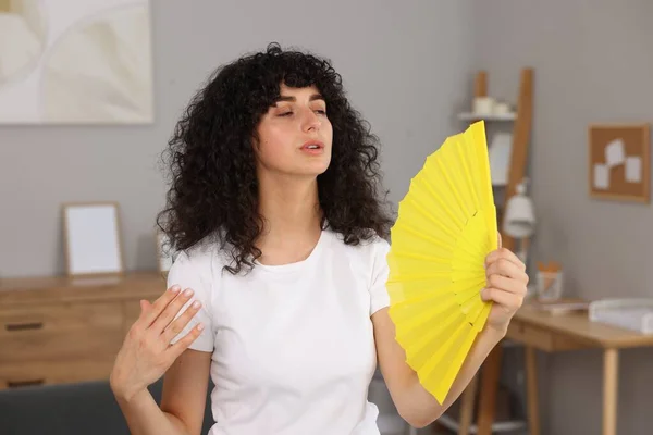 Junge Frau Schwenkt Gelben Handfächer Sich Hause Abzukühlen — Stockfoto