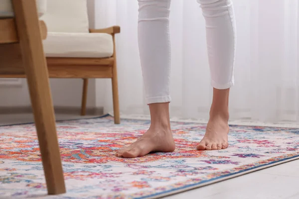 家のパターンのカーペットの上に立っている女性は クローズアップ — ストック写真