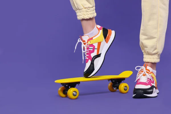 Woman New Stylish Sneakers Standing Skateboard Purple Background Closeup Space — Stock Photo, Image