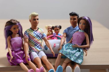 Leiden, Hollanda - 20 Eylül 2023: Güzel Barbie, Ken ve Chelsea bebekleri tahta masadaki oyuncak arabada