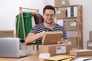 Ofiste çalışan paketli bir satıcı. Çevrimiçi mağaza