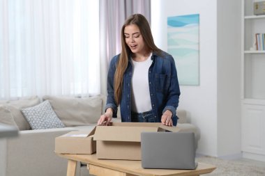 Duygusal kadın paketleri evde boşaltıyor. Çevrimiçi mağaza