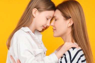 Turuncu arka planda anne ve tatlı kızının portresi.