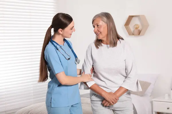 Young Healthcare Worker Assisting Senior Woman Indoors — Stock Photo, Image