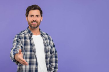 Mutlu adam karşılama ve mor arka planda el sıkışma teklif ediyor. Metin için boşluk