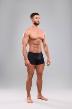 Açık gri arka planda yakışıklı kaslı adam. Seksi vücut.