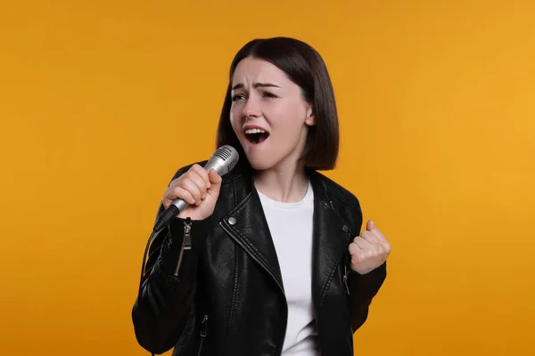 Schöne Junge Frau Mit Mikrofon Singt Auf Gelbem Hintergrund — Stockfoto